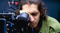 Close up of a young person filming through a professional camera