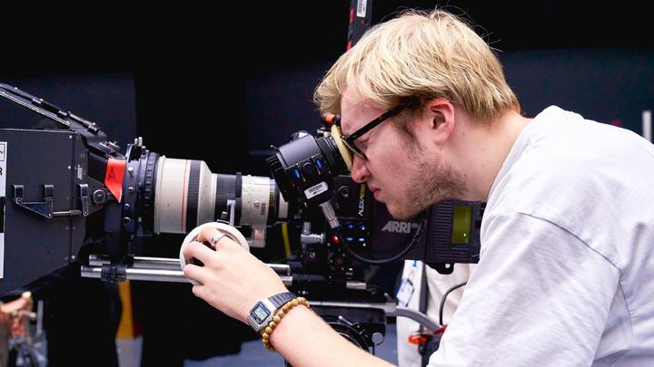Young person filming on set with a camera