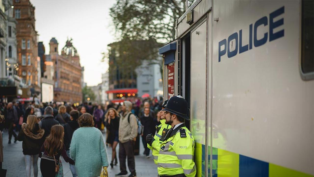 Two police officers stood next to a police van