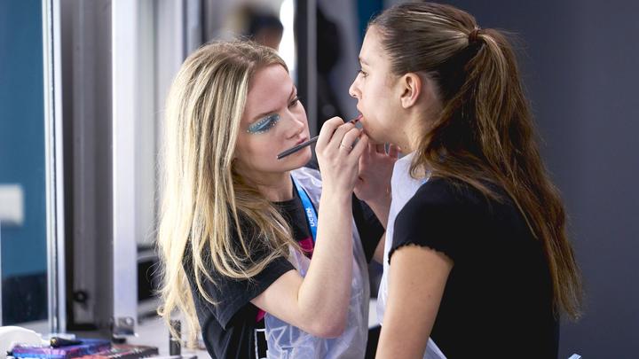 Make up student putting make up on another student