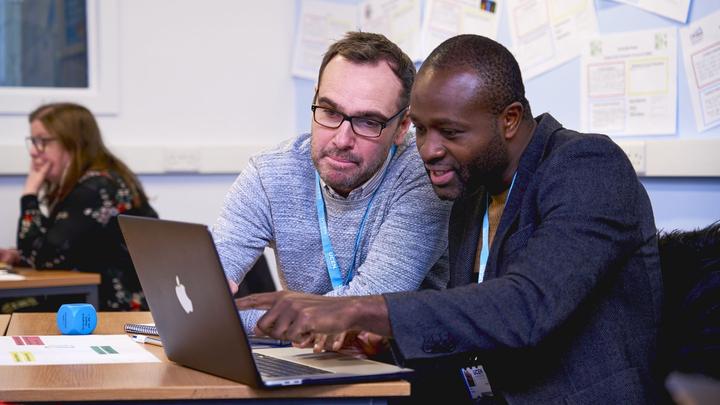 Two people working on a laptop