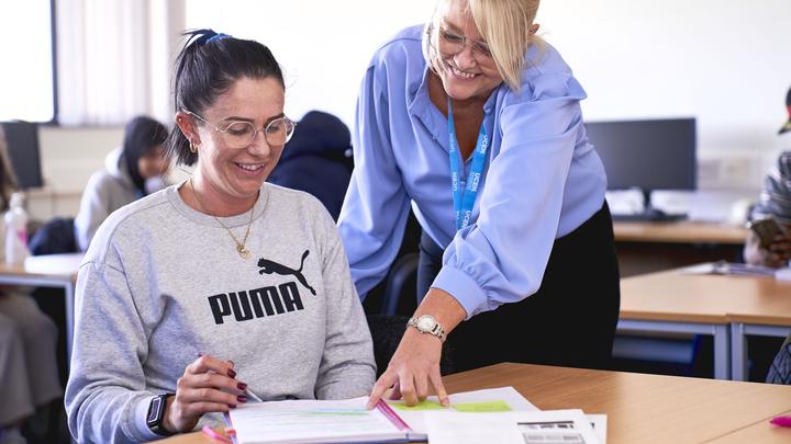 A tutor and learner smiling