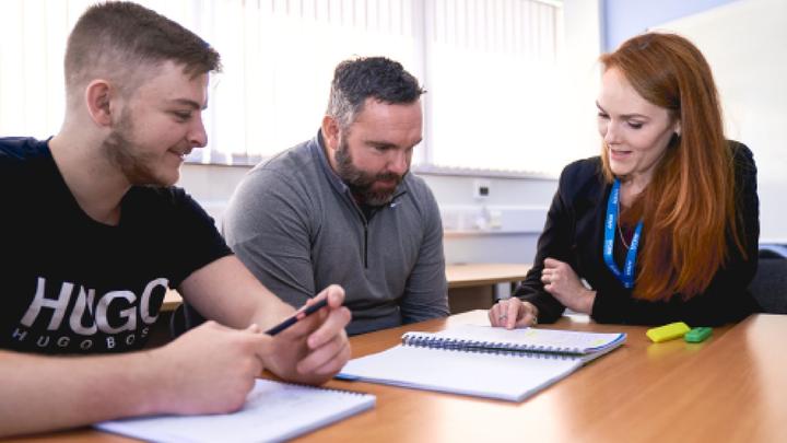 A tutor alking with two learners