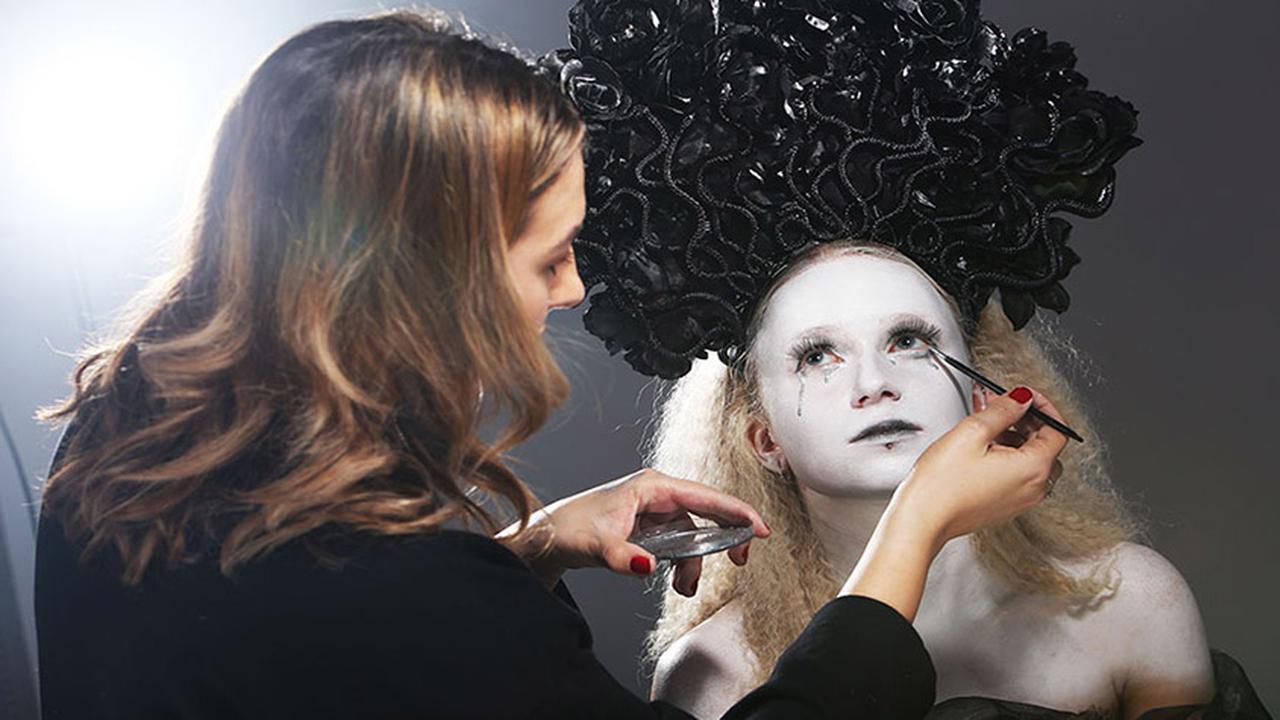 Woman practicing make-up artistry on a model