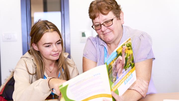 A tutor and learner looking a learning resources