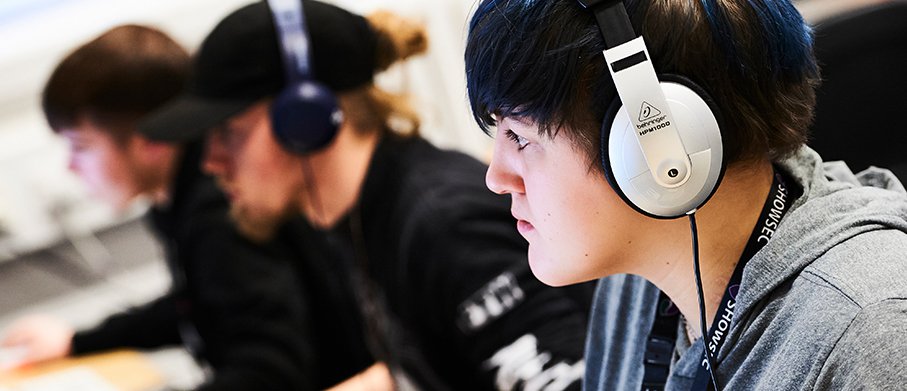 A line of students with headphones on using audio equipment
