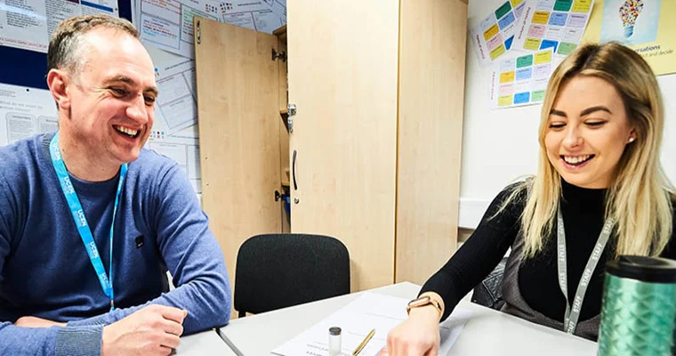 A UCEN Manchester tutor laughing with a learner