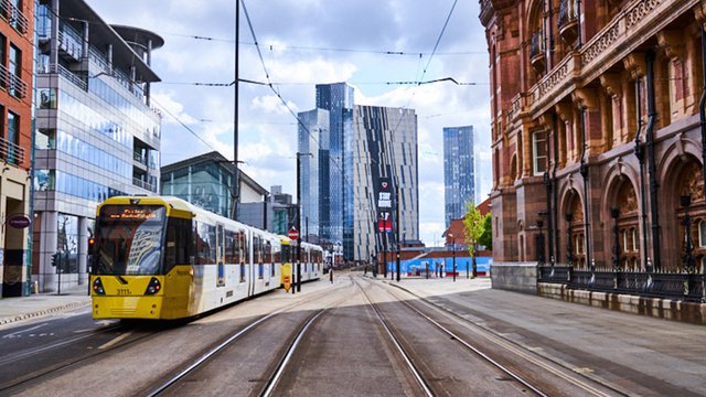 Photograph of a tram passing through Manchester city centre.