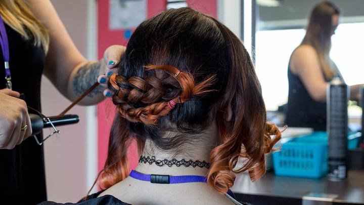 A hairdresser straightening a woman's hair
