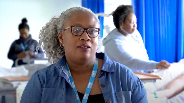 An image of Christiana as she is being interviewed in a mock hospital ward. Some of her fellow students are working in the background.