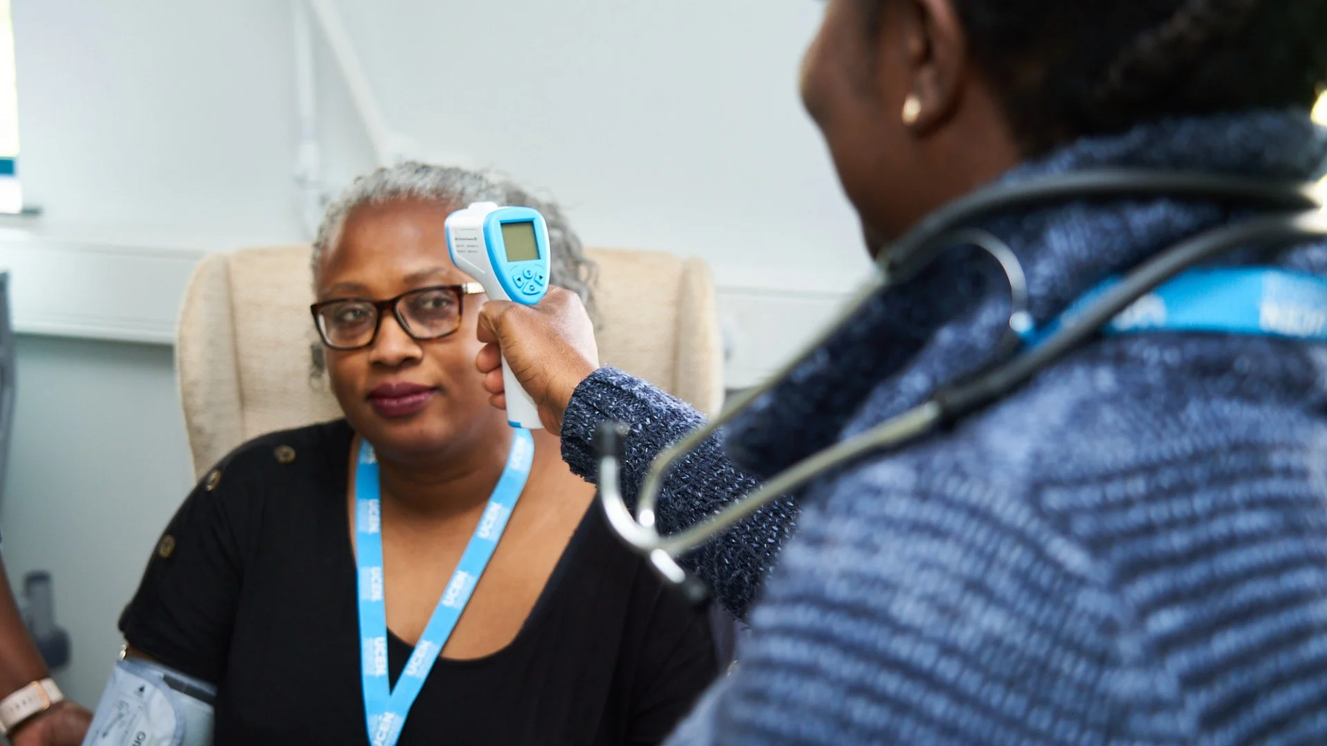 UCEN Health student measuring another students temperature