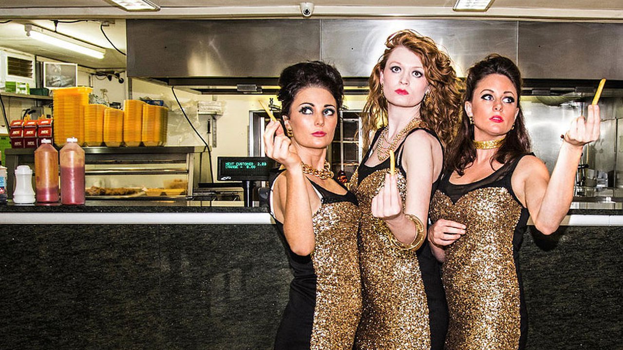 Three woman in a fast food restaurant wearing sparkly gold dresses