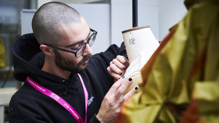 Fashion student examining their work on a mannequin