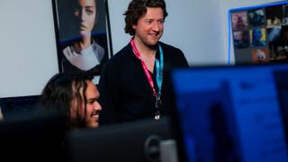Tutor supporting students in a computer classroom during a higher education lesson at UCEN Manchester.
