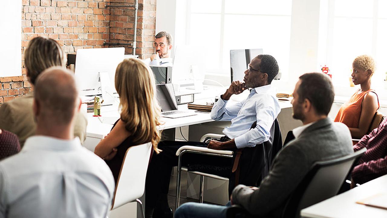 A group of people in a office looking at a business presentation