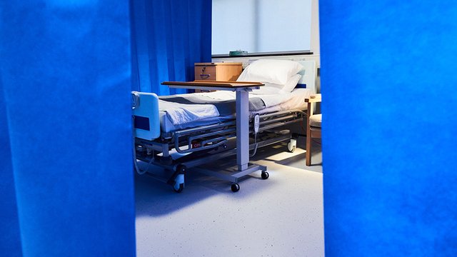 Photograph of an empty hospital bed.