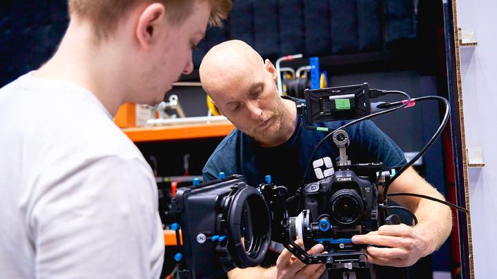 Two people setting up a camera system