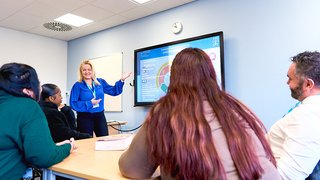 Image of Lecturer, Louise Kay, teaching a cohort of UCEN Manchester students in a classroom setting.