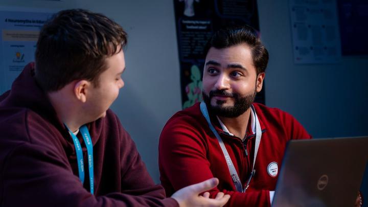 Students and tutor collaborating and discussing work while using a laptop at UCEN Manchester.