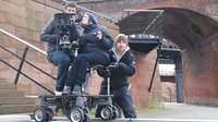 A filming crew on a film trolley