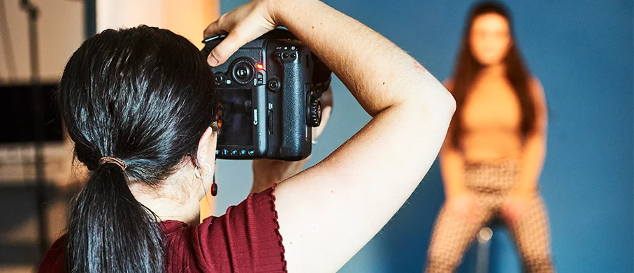 Over-the-shoulder view of a photographer taking a picture of a model