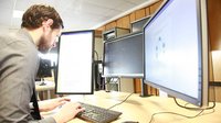 A student using multiple desktop screens