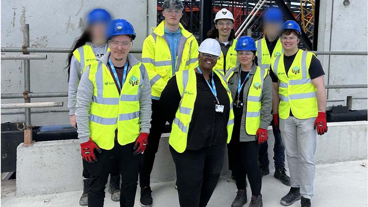 A group of Construction students in high-viz jackets stand on the roof of the Co-op Live construction site in Manchester.