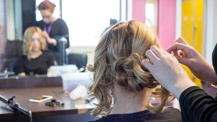 A hairdresser tying up a clients hair