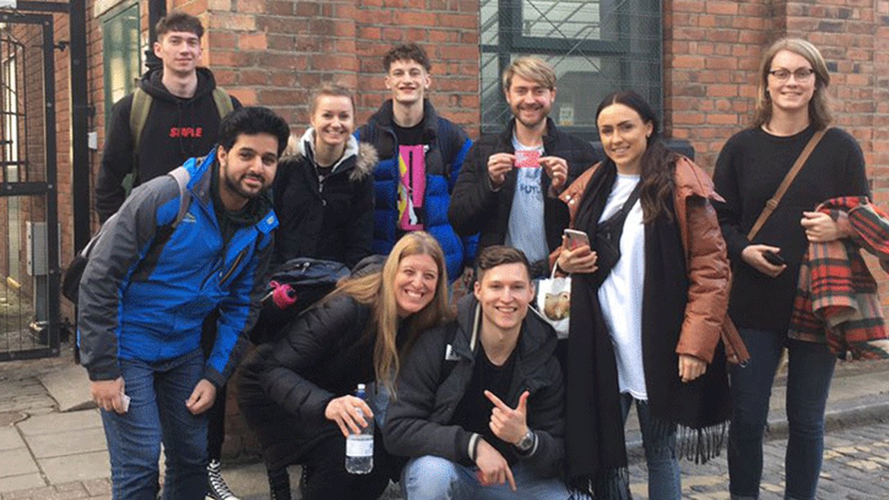 Nine creative and photographic design UCEN Manchester students all smiles during their trip to London