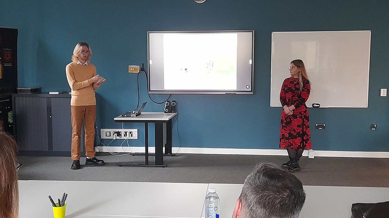 Photograph of two UCEN Manchester students presenting in a classroom to representatives from the Intellectual Property Office.