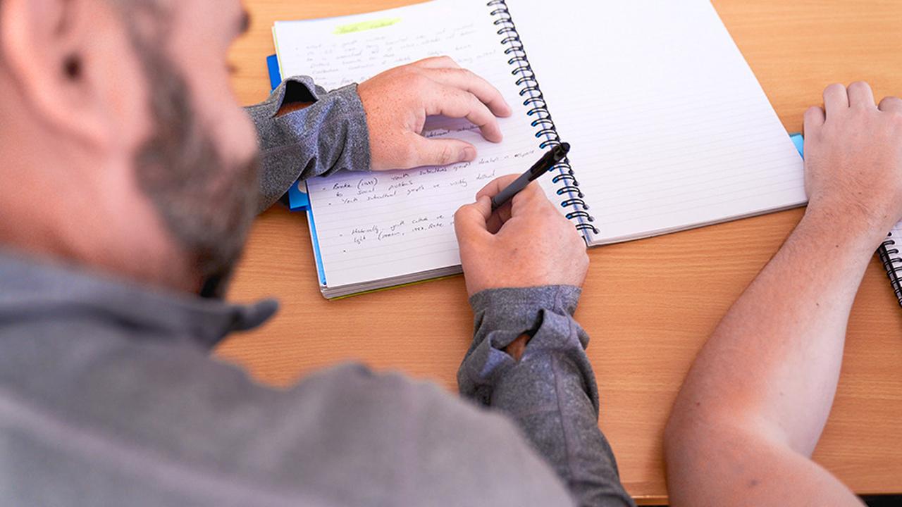 Photograph of a UCEN Manchester Criminology and Criminal Justice student taking notes.