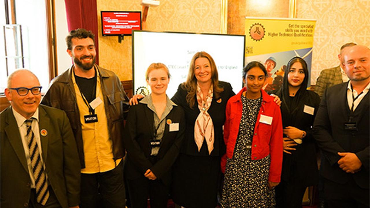 Seven people standing in a row and smiling at the camera.