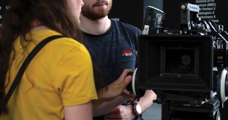 Two film students using a piece of camera equipment