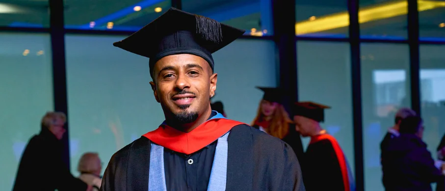 A young person wearing a graduation cap and gown
