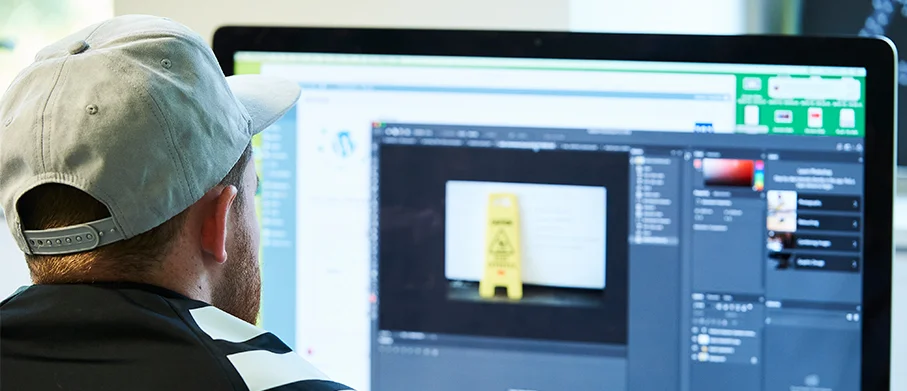 Over-the-shoulder of a student using photoshop on an iMac