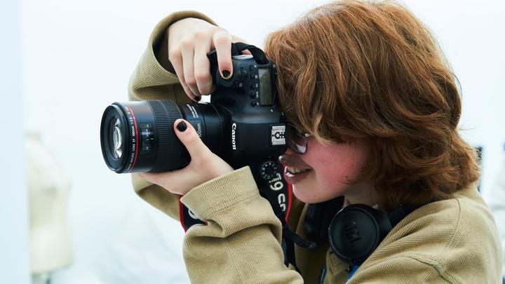 Close-up of a learner usng a DLSR camera