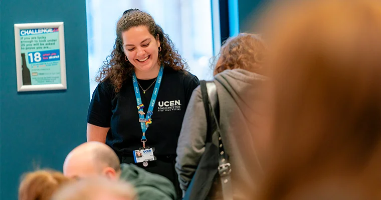 A UCEN Manchester tutor laughing and talking with prospective students