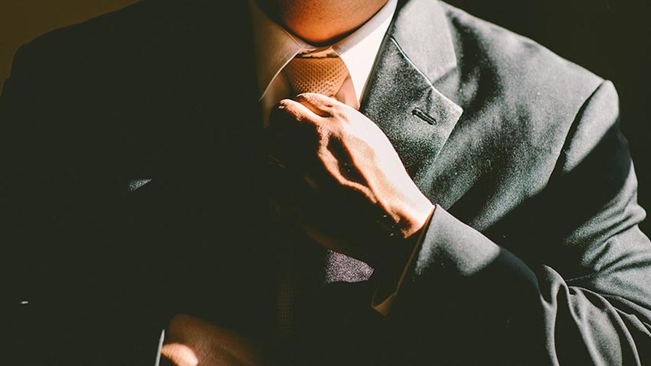 Close-up of a man tying up his tie