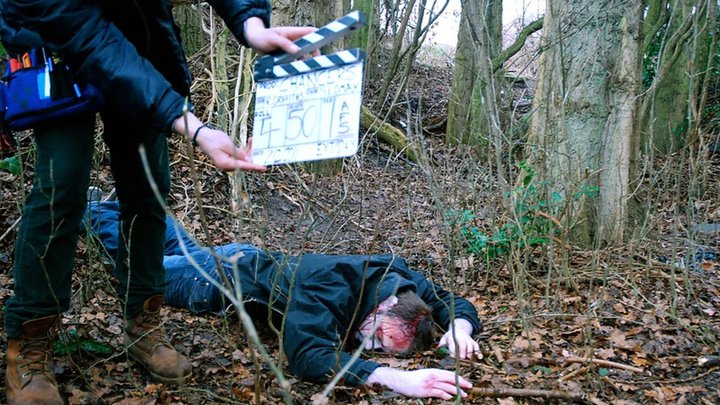 Close-up of someone using a film action board (clapperboard)