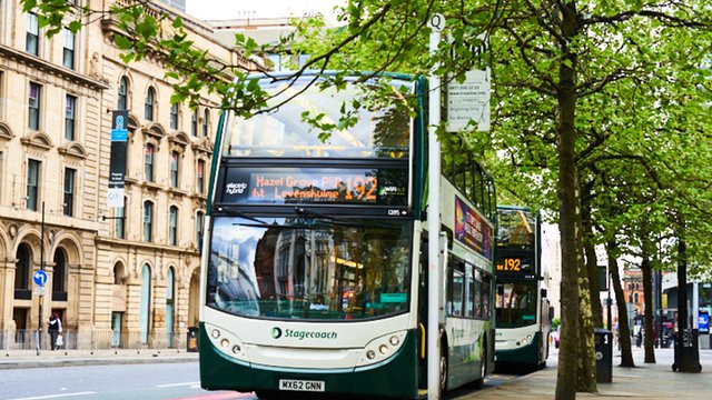 Photograph of a double decker bus parked at a bus stop in Manchester.
