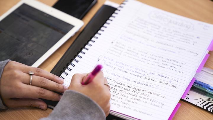 Health learner writing on her notepad