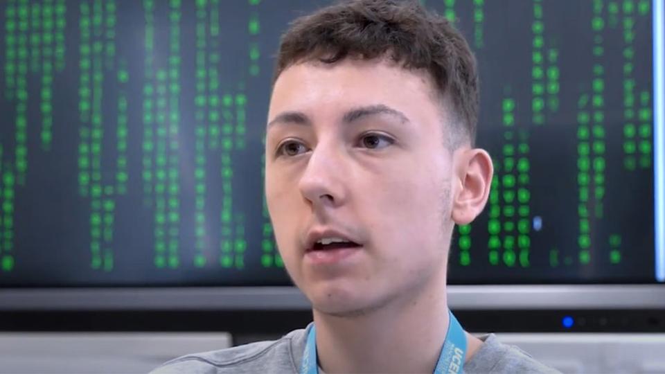 A photograph of Szymon while he is being interviewed.