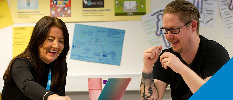 A UCEN Manchester tutor laughing with a learner
