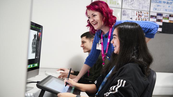 A group of people using a computer and a graphic tablet