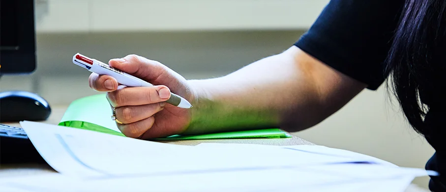 Close-up of someone signing documents
