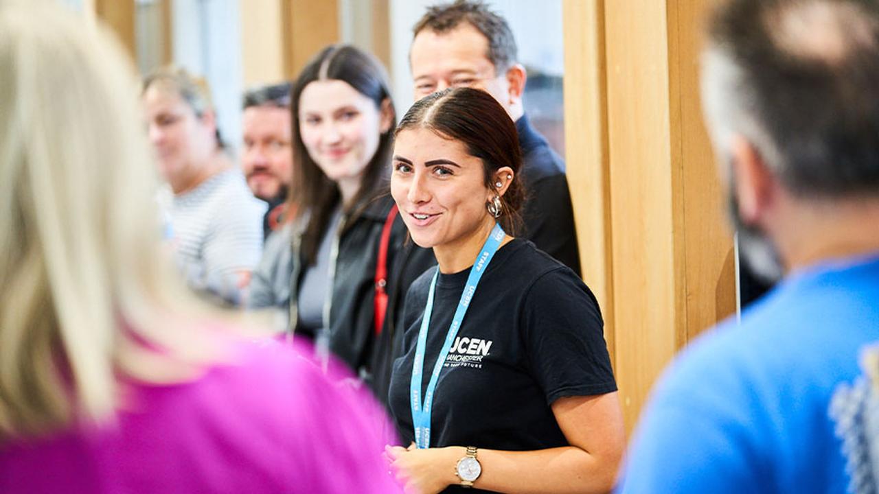 A member of the UCEN Manchester Student Support team is in the centre of the frame. She's giving Open Event guests a tour of City Campus Manchester.