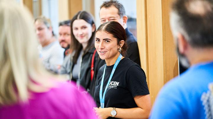 A member of the UCEN Manchester Student Support team is in the centre of the frame. She's giving Open Event guests a tour of City Campus Manchester.