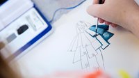 Close-up of someone painting a costume design