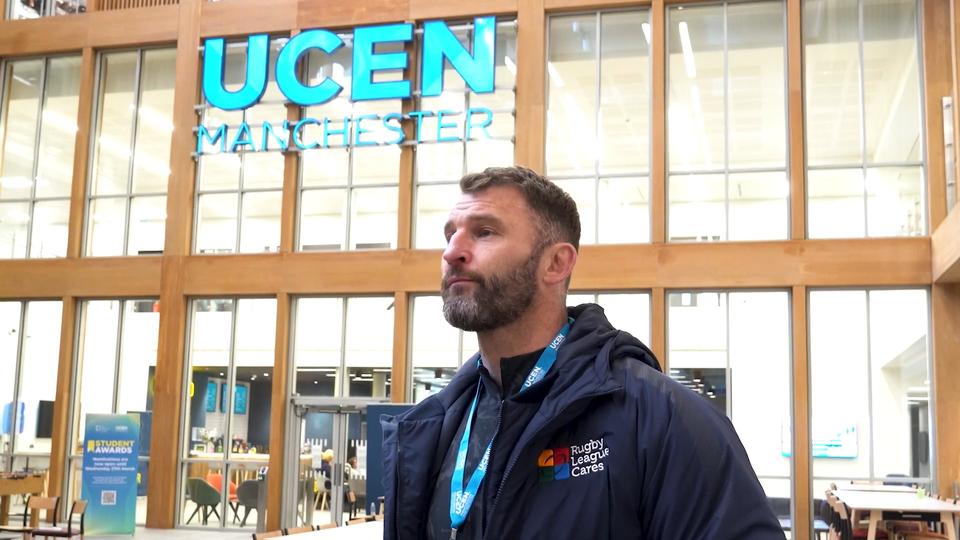 Business and Leadership student Paul in front of the UCEN Manchester sign at our City Campus