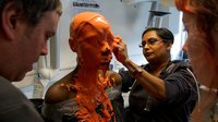 Students applying a face mould to a model
